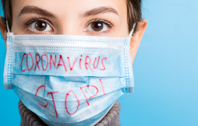 Portrait of a woman in medical mask with stop coronavirus text at blue background. Coronavirus concept. Respiratory protection.